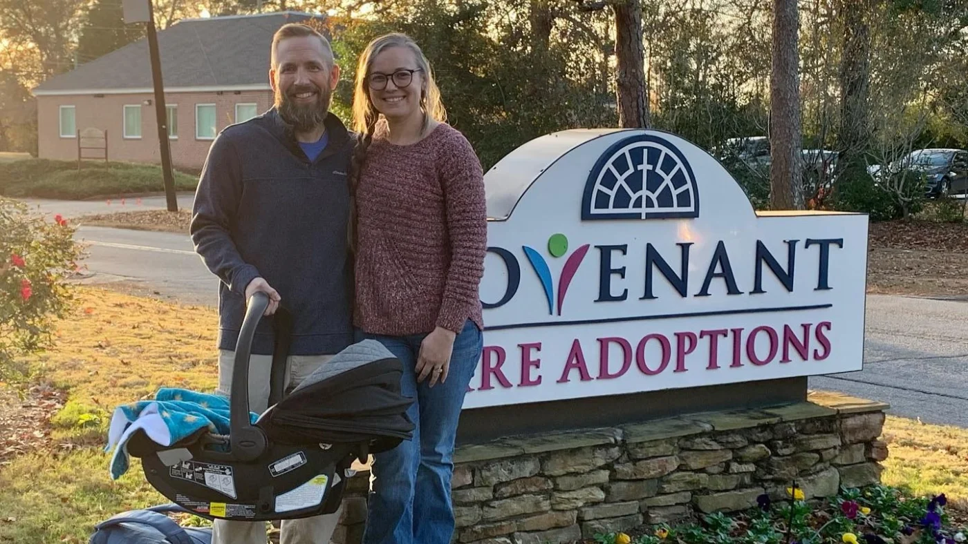Covenant Care Adoption Agency Middle Georgia Sign A man and a woman with a new baby standing by the Covenant Care Adoption Agency sign in Macon Georgia.